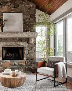 a living room with a stone fireplace and two chairs