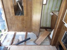 the inside of a house being remodeled with wood flooring and walls torn off to reveal wallpaper