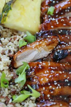 chicken and rice on a plate with broccoli, pineapple slices and sesame seeds