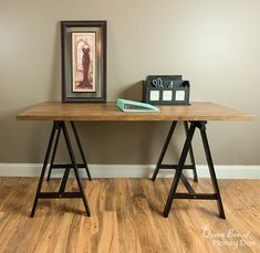 a wooden table with a framed picture on top and a binder next to it