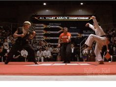 an autographed photo of two men performing karate moves in front of a crowd