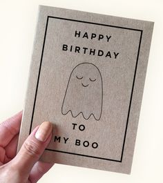 a hand holding up a card with a ghost on it that says happy birthday to my boo