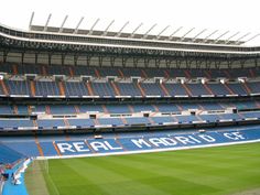 an empty soccer stadium with blue seats and the words real madrid on the sidelines