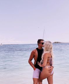 a man and woman kissing on the beach