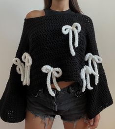 a woman wearing black and white knitted sweater with bows