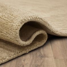 a close up view of a rug on the floor with wood grained floors in the background