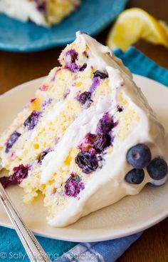 a slice of lemon blueberry cake on a plate with a fork next to it