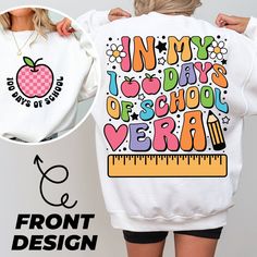 the back of a woman's sweatshirt with an apple and ruler design on it