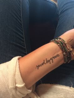 a woman's arm with the words never thy grace tattooed on her left arm