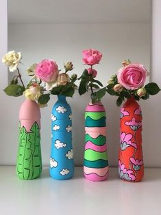 three painted vases with flowers in them