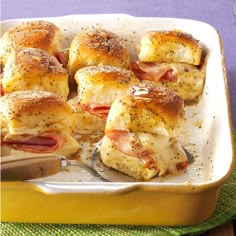 a casserole dish filled with ham and cheese wrapped in puffy bread, ready to be eaten