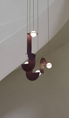 three lights hanging from the ceiling in a room with white walls and ceilings above them