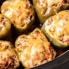 stuffed bell peppers in a slow cooker with cheese on top and meat inside the middle