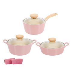 three pink pots with wooden spoons and one has a brown handle on it, while the other is white