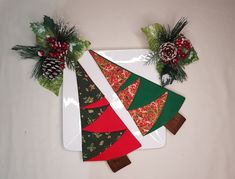 three christmas tree napkins on a white plate