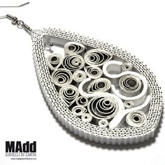 a pair of earrings is shown on a white background with the words madd written below it