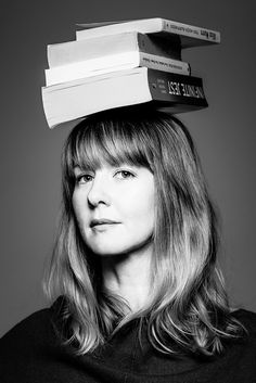 a woman with books on top of her head