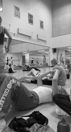 a group of people laying on the floor in a gym with their backs turned to one another