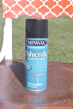 a can of spray paint sitting on top of a wooden table next to a bench