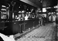 an old black and white photo of people at the bar