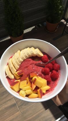 a white bowl filled with fruit and banana slices