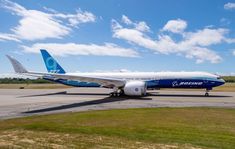 a blue and white airplane is on the runway