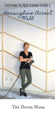 a woman standing in front of a white wall with a black and gray dog on a leash