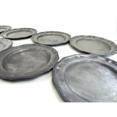 a group of silver plates sitting on top of a white table