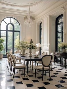 an elegant dining room with black and white checkered flooring, chandelier and large windows