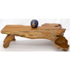 a wooden table with a blue vase on it's top and one piece of wood that has been turned into a bench