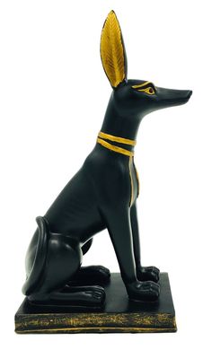 a statue of an egyptian dog sitting on top of a black base with gold trimmings