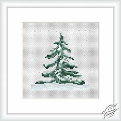 a cross stitch christmas tree with snow on the ground and green frame in front of it