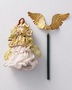 a golden angel figurine next to a green marker on a white surface with a black pen