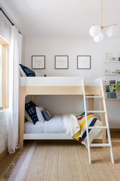 there is a bunk bed with a ladder on the bottom and a rug underneath it