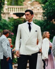 a man in a white suit and black tie