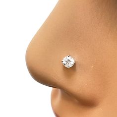 a woman's nose with a single diamond in the middle of her nose and an earring attached to it