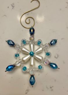 a snowflake ornament hanging from a hook on a marble counter top