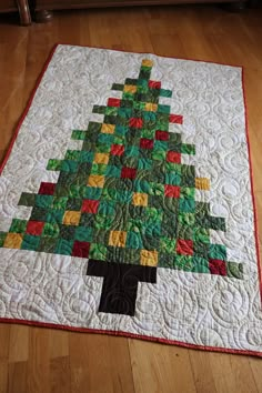 a quilted christmas tree is displayed on the floor