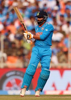 a man holding a cricket bat on top of a field