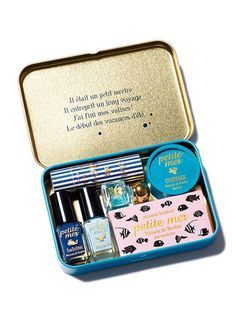 an open tin box containing nail polish and cosmetics