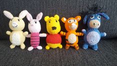 crocheted winnie the pooh and friends amigurt toys lined up on a couch