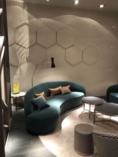 a living room filled with lots of furniture next to a wall covered in hexagonal tiles