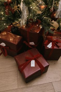 presents under the christmas tree are wrapped in red ribbon