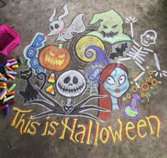 this is halloween written in chalk on the ground next to crayons and markers