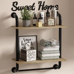 a shelf with towels and other items on top of it next to a sign that says sweet home