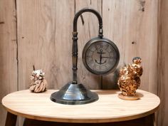 an old fashioned clock sitting on top of a wooden table