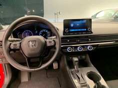 the interior of a car with an electronic display and steering wheel, dash board, dashboard lights, and other accessories