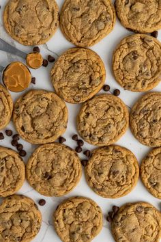 chocolate chip cookies and peanut butter on a white surface with coffee beans scattered around them