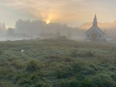 a small church in the middle of a foggy field