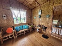 a living room filled with furniture and wooden floors next to a wall covered in bamboo